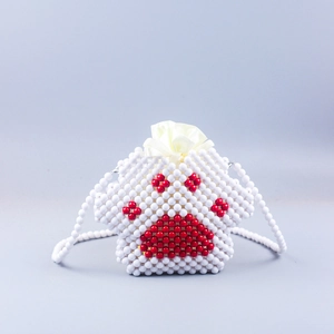 Close-up of handmade beaded cat paw crossbody bag with white beads and red pad pattern
