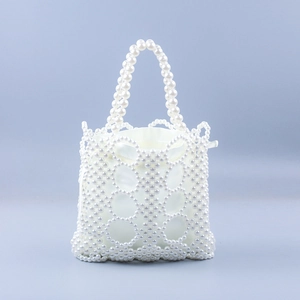 Detail view of handmade pearl woven handbag featuring openwork texture and satin inner bag