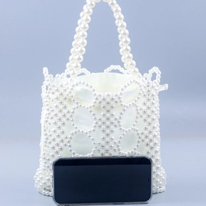 Fashionable white handmade pearl woven handbag with a satin drawstring inner bag