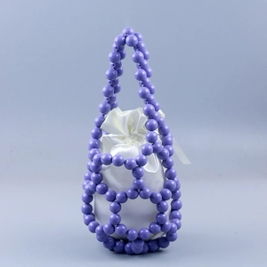 Detail of purple hand-woven beaded bucket bag with white satin drawstring liner