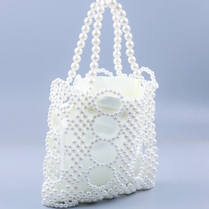 Detail of white pearl beaded handbag showing woven pattern and fabric lining