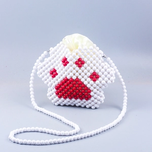 Detailed view of handmade beaded cat paw crossbody bag with white beads and red claw pattern
