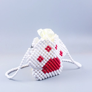 Detail of handmade beaded cat paw crossbody bag with white beads and red dot accents