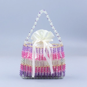 Handmade rainbow beaded handbag with a colorful gradient finish and white satin drawstring pouch
