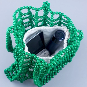 Green handmade beaded tote bag with hollow grid pattern and white drawstring inner pouch