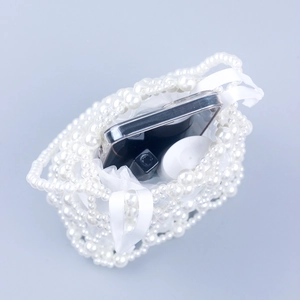 Stylish white pearl woven handbag with satin ribbon showing internal capacity for cosmetics