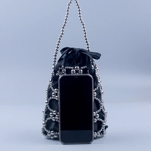 Detail view of silver beaded handbag with black silk drawstring inner bag and metal handle