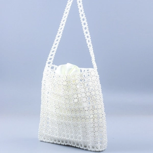 Vue détaillée du sac à main en perles blanches tissées avec doublure en soie et sangle