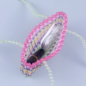 Vue intérieure du mini sac en perles acryliques avec écouteurs sans fil et rouge à lèvres