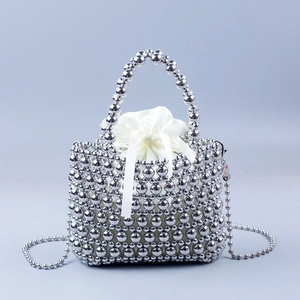 Dettaglio della borsa a cesto in perle argento con custodia in raso bianco e finitura