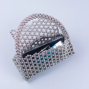 Macro detail of the woven silver beaded handbag showing internal storage for phone and makeup