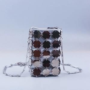 Detail of silver sequin phone bag with metal mesh texture and crossbody chain strap
