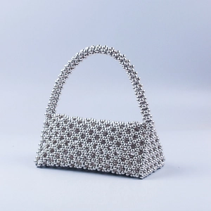 Detailed view of handmade silver metallic beaded handbag with intricate woven textures