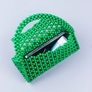 Detail of green beaded handbag showing capacity for phone and lipstick