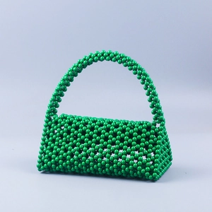 Detail of handcrafted vibrant green beaded woven handbag with glossy resin bead texture