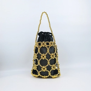 Detailed view of handmade gold beaded handbag with black satin drawstring lining pouch