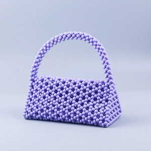 Detailed texture of handcrafted light purple beaded handbag with intricate woven structure
