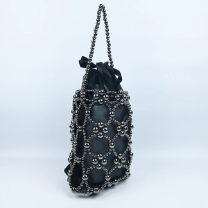 Detail of gunmetal beaded bucket bag with drawstring satin lining and woven hollow design
