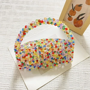 Detail of colorful handmade beaded bag featuring vibrant rainbow pearls and a top handle
