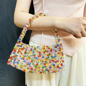 Detail of colorful transparent beads on a handmade woven handbag with dopamine style