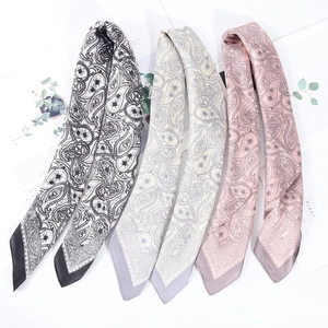 Detailed view of three paisley print silk scarves in black, beige and purple colors
