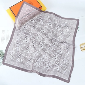 Detail of paisley print silk scarf with purple edges and soft fabric texture draping