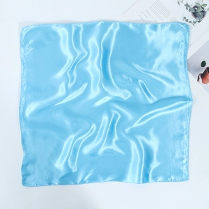 Close-up of the sky blue satin square scarf with fine stitched edges and silky texture