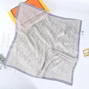 Close-up of elegant grey paisley print square silk scarf with smooth satin finish