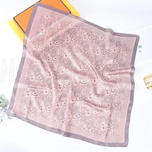 Elegant purple paisley silk square scarf displayed with a luxury gift box and magazines