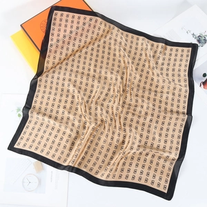 Detail of silk-like square scarf with butterfly pattern on champagne satin fabric