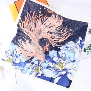 Detailed close-up of 70cm silk scarf with gold fish and peony prints on white surface