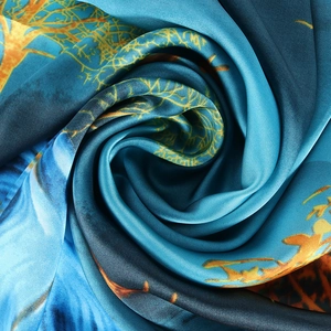 Elegante pañuelo de seda azul y naranja con estampado de ramas en pliegue espiral