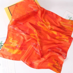 Lebhaftes oranges Camouflage Seidentuch auf weißem Hintergrund mit Geschenkbox