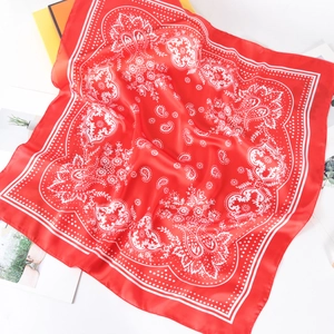 Dettaglio della stampa paisley bianca su un foulard quadrato in seta rossa da 70 cm