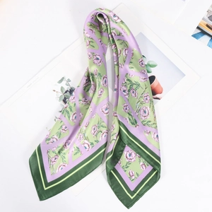 Detail of floral print silk scarf featuring elegant green and lavender flower patterns
