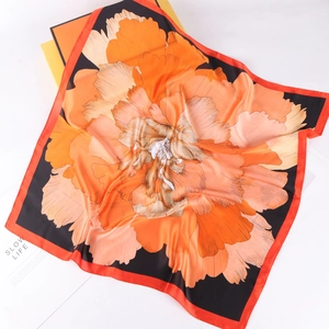 Detail of silk square scarf featuring vibrant peony floral pattern and elegant gift box