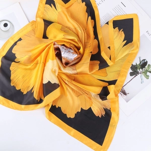 Detailed view of 70cm silk scarf with yellow peony pattern on black satin fabric