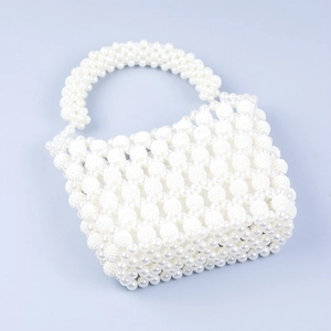 Detail of white handmade beaded handbag with woven faux pearls and vintage baroque style