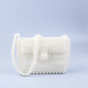 Close-up of elegant white acrylic pearls on the woven square crossbody bag texture