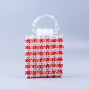 Macro shot of colorful handmade beaded handbag featuring transparent acrylic handles