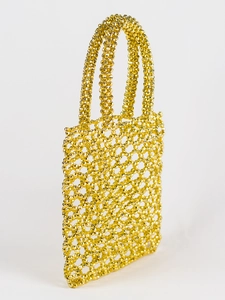 Détail de gros plan des perles facettées dorées tissées sur un sac à main géométrique