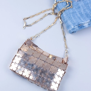 Detail of gold metal square sequins and chain strap on futuristic crossbody bag