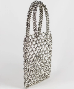 Détail macro du sac à main en perles argentées avec motif géométrique ajouré tissé