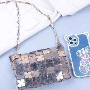Detail of gold square sequins and metallic hollow chain on a futuristic crossbody bag