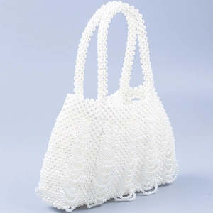 Close-up of handmade white pearl woven handbag with wavy texture and scalloped hem