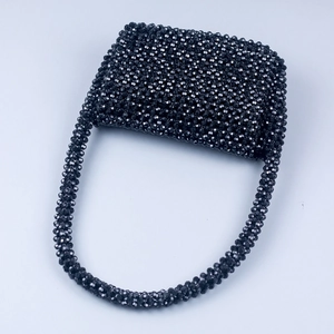 Close-up of hand-woven black acrylic faceted beads and structure of the evening handbag