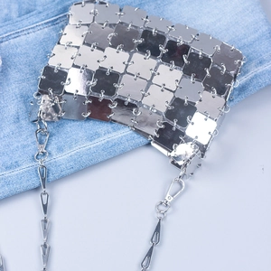 Close-up of silver square metal sequins with a scale-like texture on a chain bag