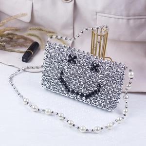 Silver woven beaded shoulder bag with smiley face and elegant pearl strap detail