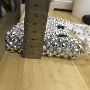 Detail showing the 35mm thickness of the silver beaded crossbody bag with a metal ruler