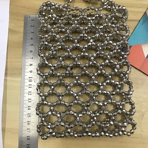 Détail du sac bandoulière argenté perlé avec mesure de 19cm sur fond en bois
